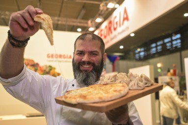 A chef holding food from the Balkan.