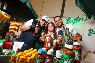 Two men and a woman present a salsa seasoning at the Grüne Woche 2024
