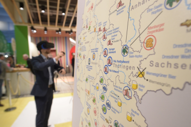 A man with virtual reality glasses digitally explores the map of Germany.