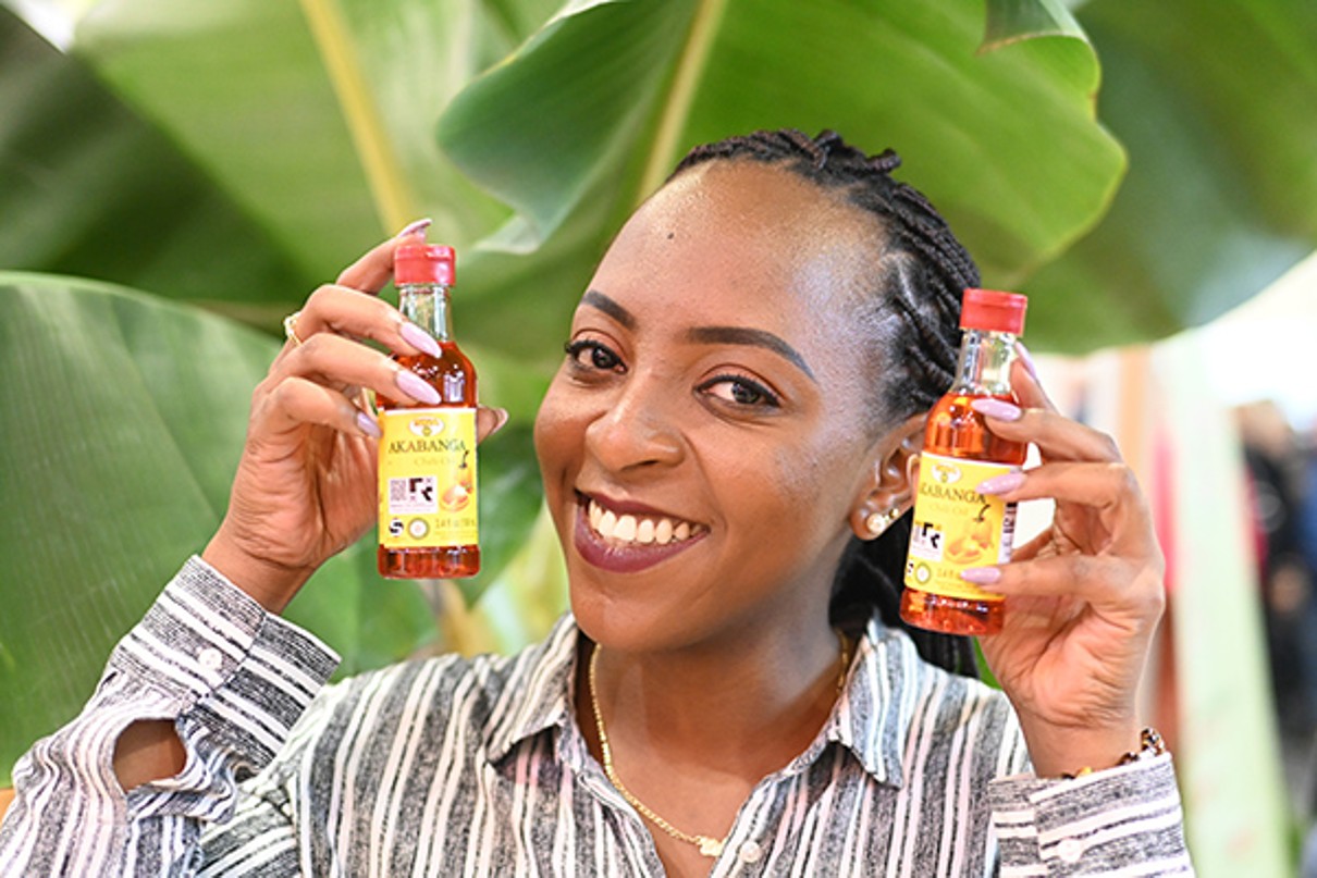 A woman holds two bottles of hot chili sauce.