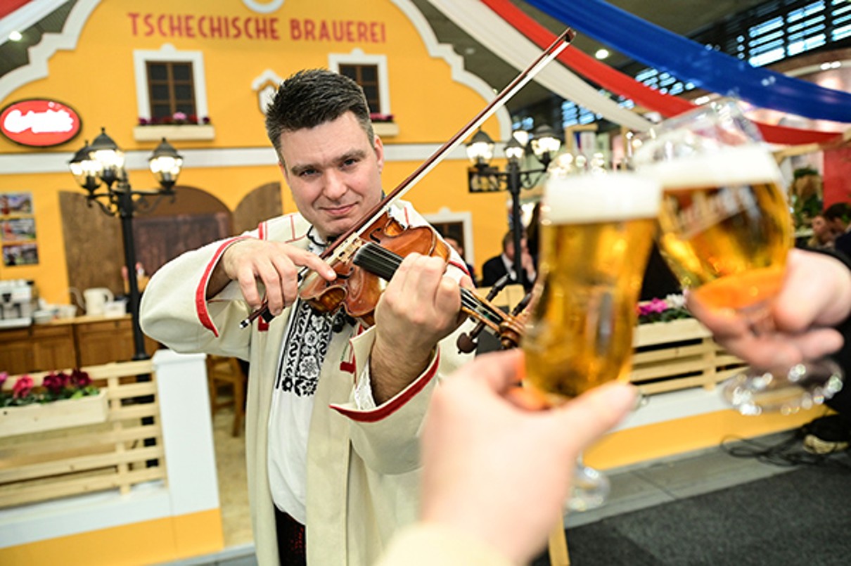 A Czech violin player in front of the Czech stand.