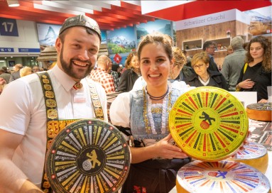 Swiss exhibitors presenting cheese wheels.